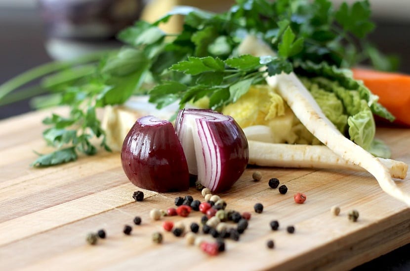 cebolla roja partida por la mitad encima de una tabla de alimentos