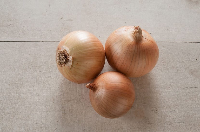 tres cebollas de tamano mediano llamadas cebolla amarilla