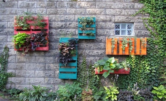 Palets de madera reutilizados como jardineras y mobiliario en un jardín